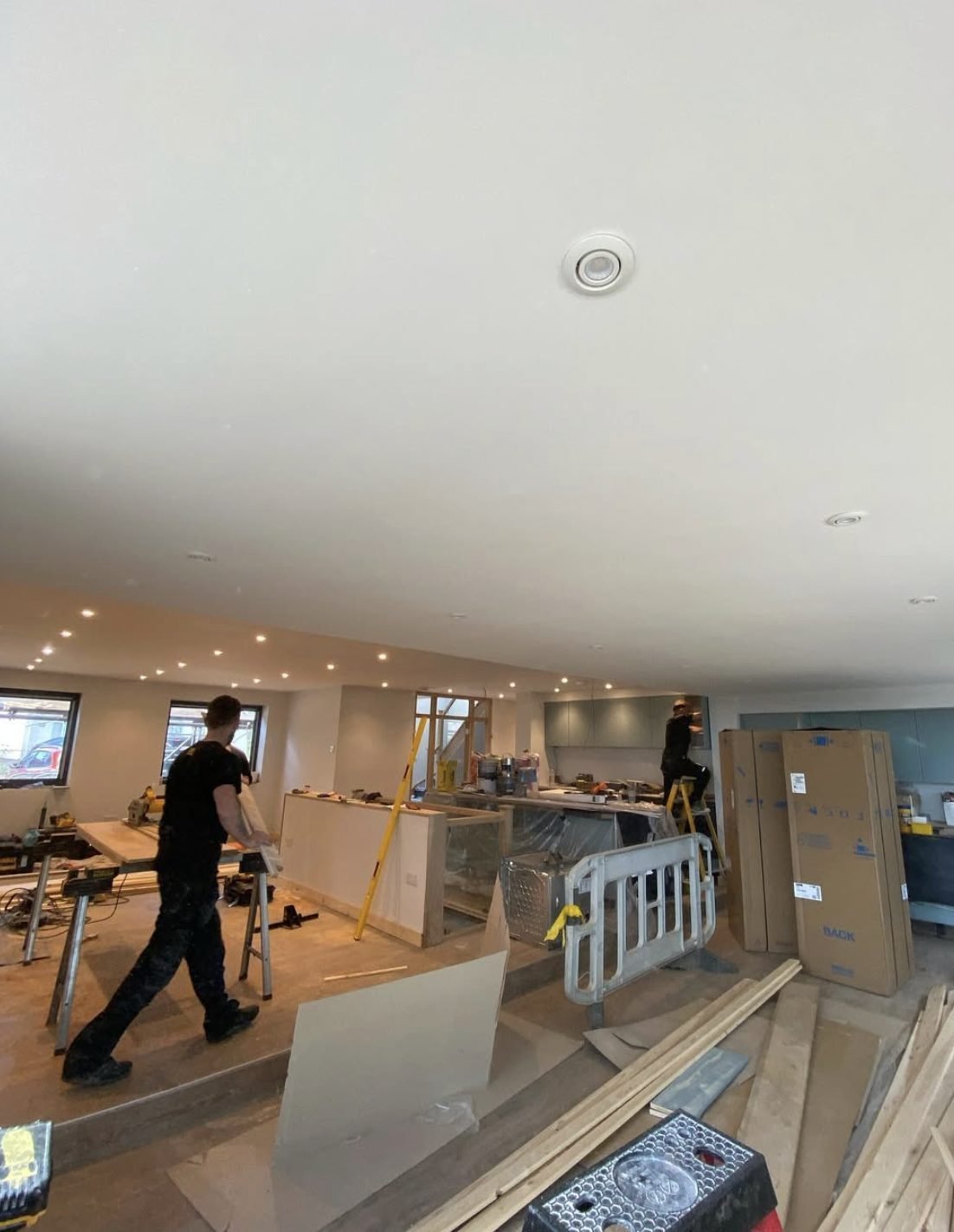 Recessed downlights installed across a newly plastered open-plan ceiling