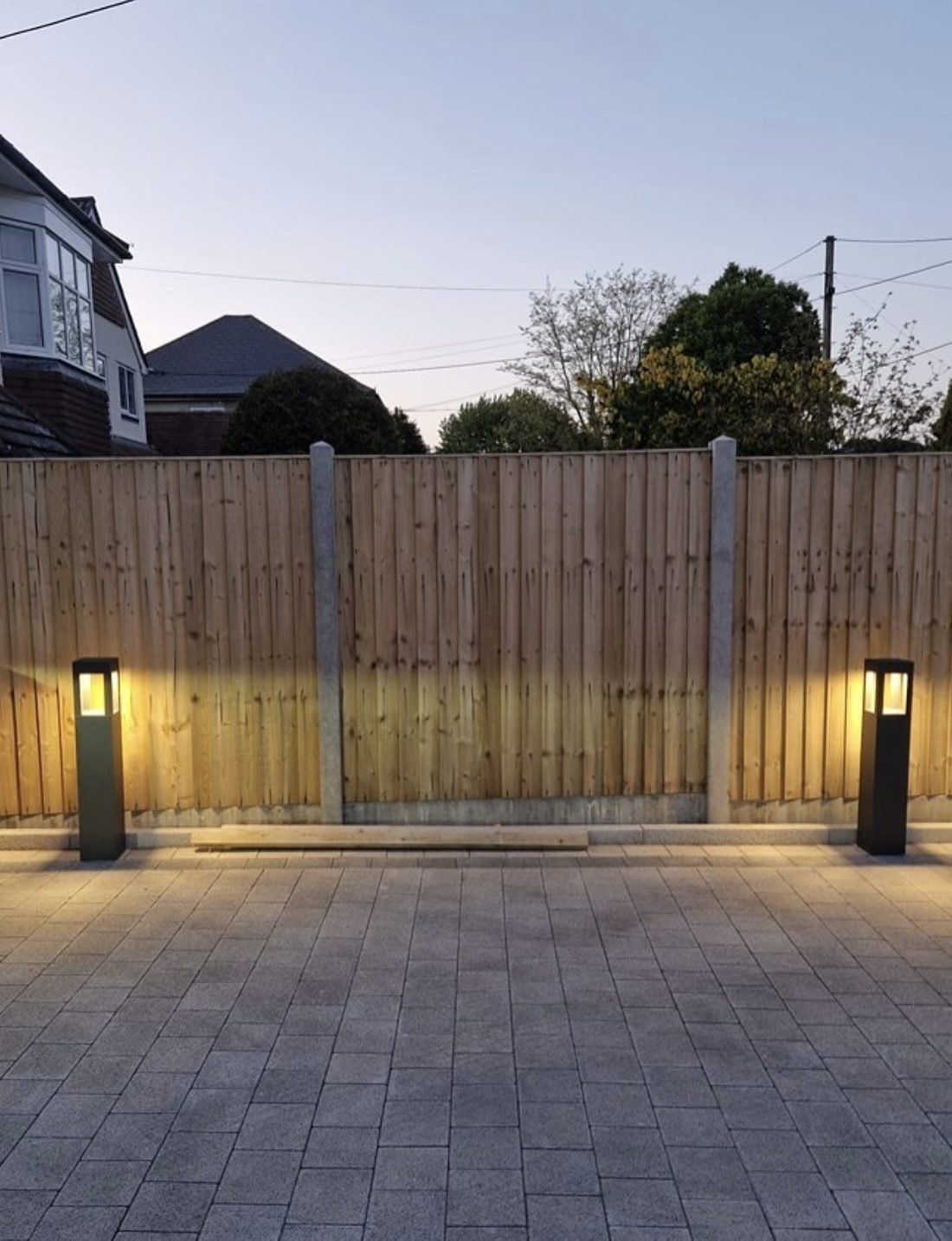 Bollard lights lighting a block paved driveway at dusk